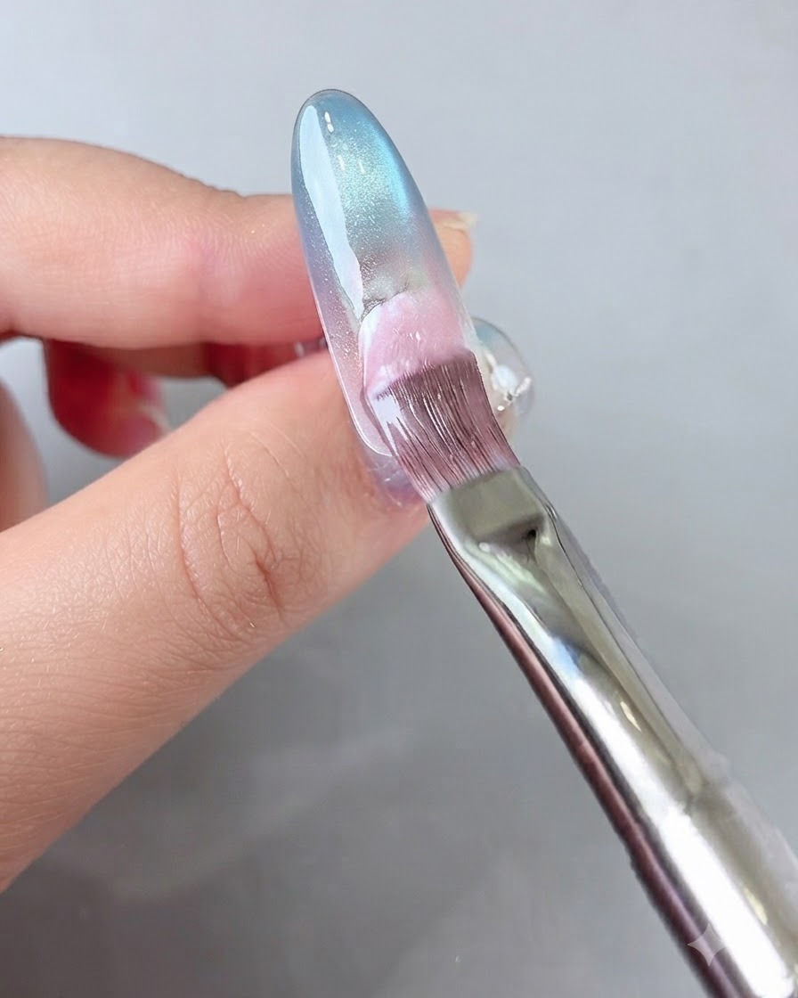 Un pennello che applica il gel rosa sulla parte posteriore dellunghia.