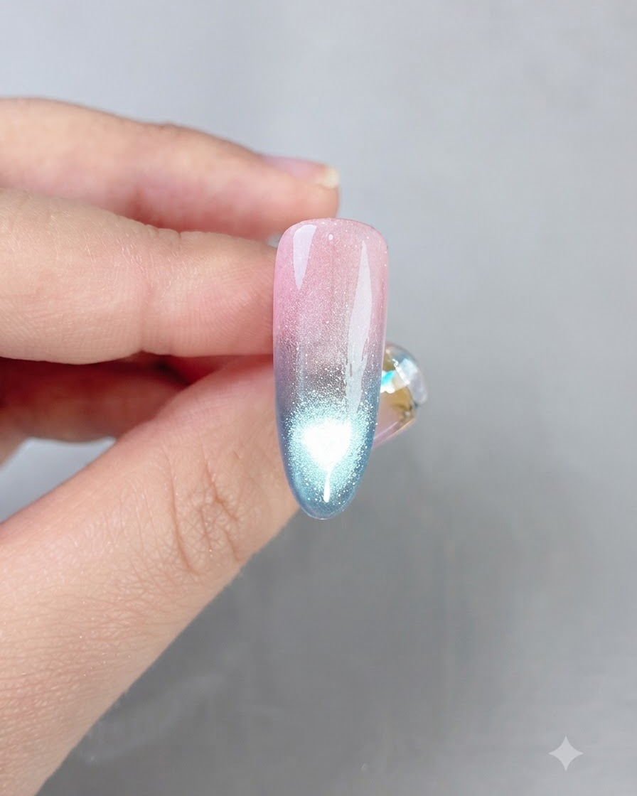 Ununghia rifinita con sfumatura rosa e blu che mostra una brillante linea di riflessione cat eye lungo il centro.