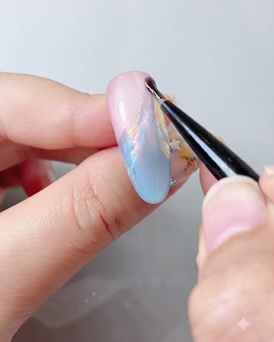 Un pennello per unghie fine che applica un top coat trasparente su una superficie lucida multicolore dellunghia.
