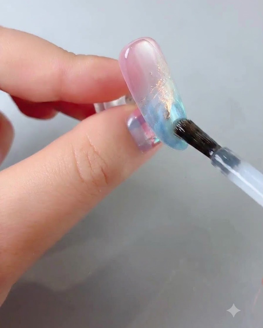 Un pennello per unghie che fa scorrere un top coat trasparente e lucido sulla superficie dellunghia decorata.