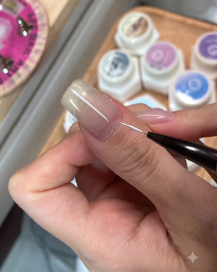 Un pennello per dettagli sottili che applica il top coat su una singola unghia.