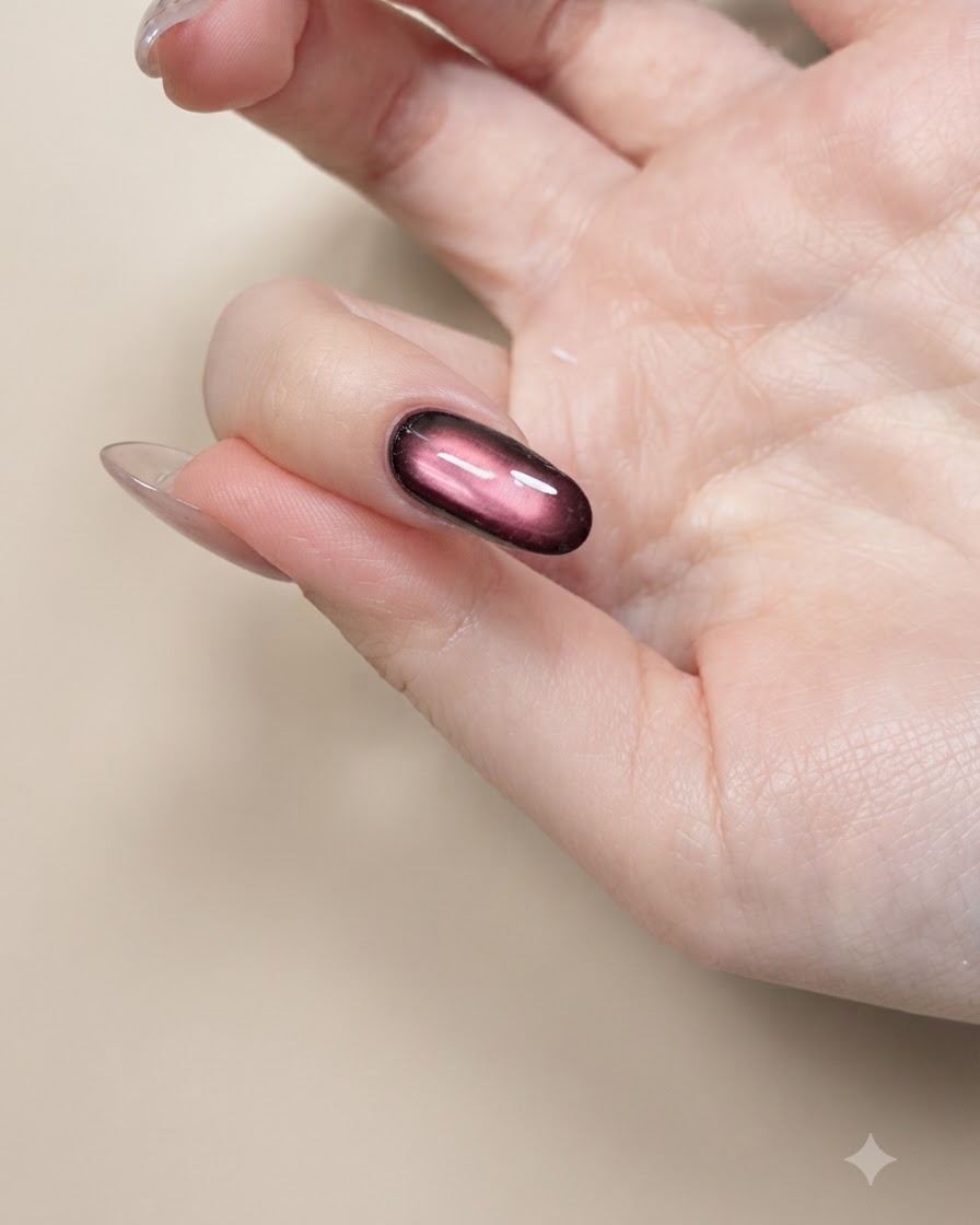 Un pennello sottile per nail art che dipinge contorni neri di ali di farfalla su ununghia nude.