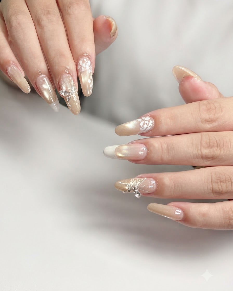 Inquadratura macro di un unghia dell anulare con intricata nail art in pizzo floreale bianco su base sfumata nude.