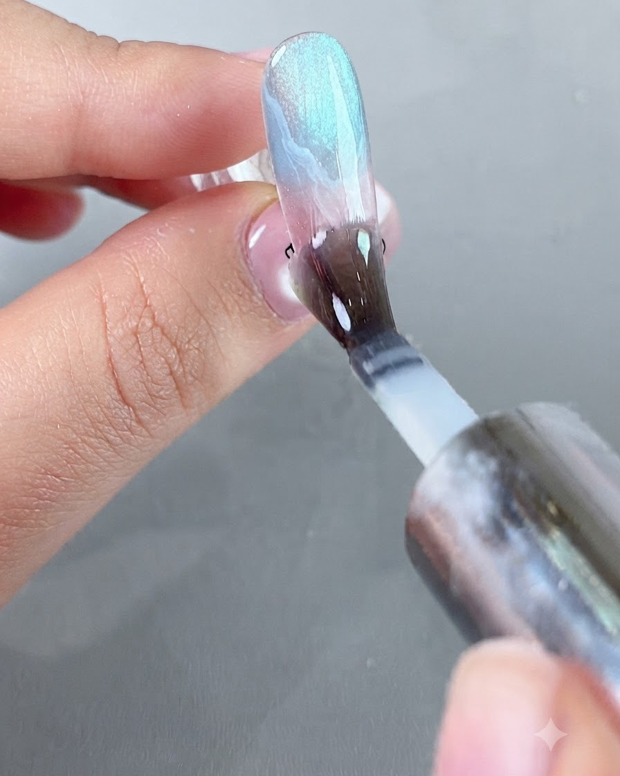 Un pennello che stende uno strato liscio di top coat protettivo isolante sulla superficie decorata dellunghia.