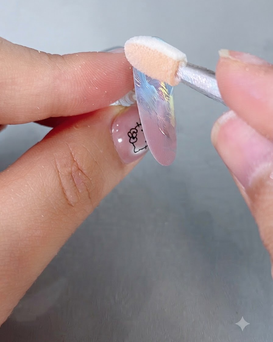 Un applicatore in spugna per ombretto che lucida la polvere specchio magico iridescente su una punta color pastello.