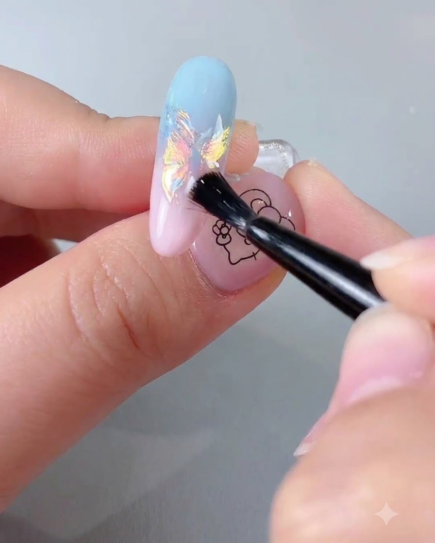 Un pennello che applica un top coat sigillante trasparente su una ricostruzione unghie con finitura cromata iridescente.