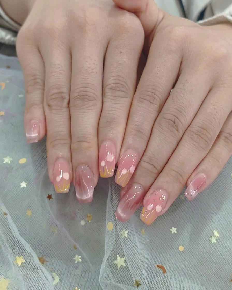 Un pennello per ombré sfuma delicatamente lo smalto gel rosa e giallo al centro dellunghia.