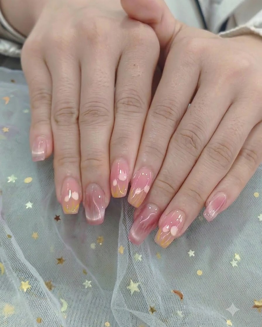 Un pennello stende un top coat lucido su un design completato con cuori e sfumatura.