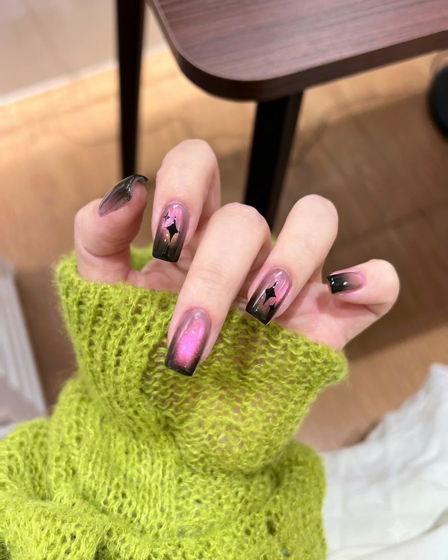 Applicazione di un tocco concentrato di smalto gel nero scuro sulla punta di ununghia sfumata.