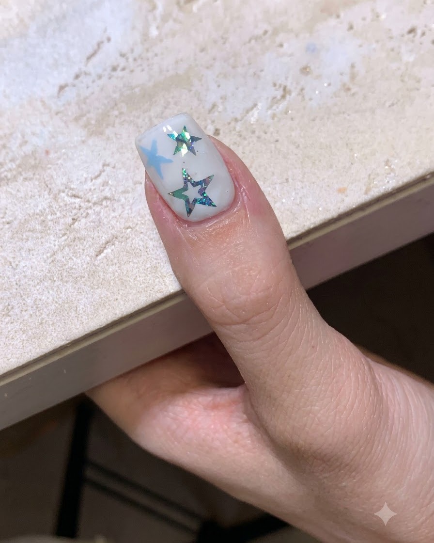 Una manicure a tema stellare completata che polimerizza sotto una lampada per unghie.