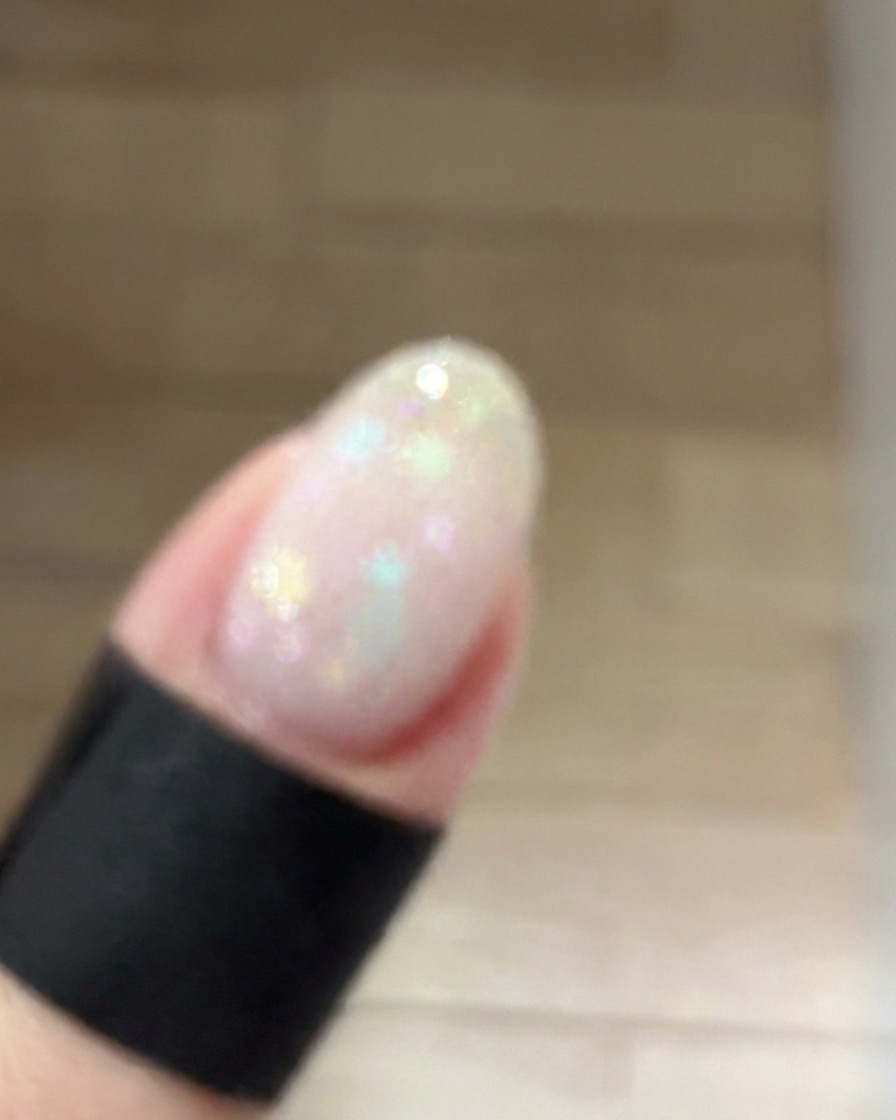 Una piccola spugnetta per il trucco che picchietta delicatamente del gel rosa antico al centro di ununghia per creare una morbida sfumatura blush.