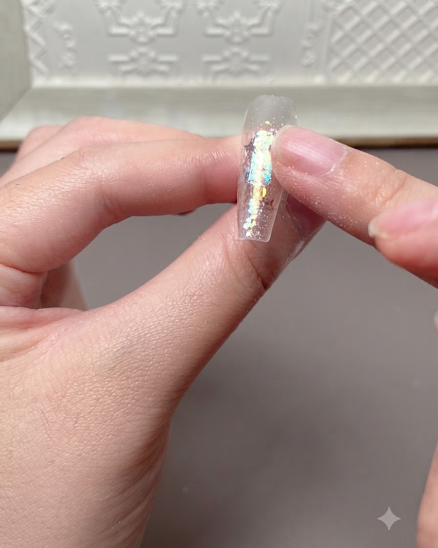 Un dito che preme leggermente o controlla la superficie di unextension per unghie polimerizzata dopo essere stata sotto una lampada UV o LED.