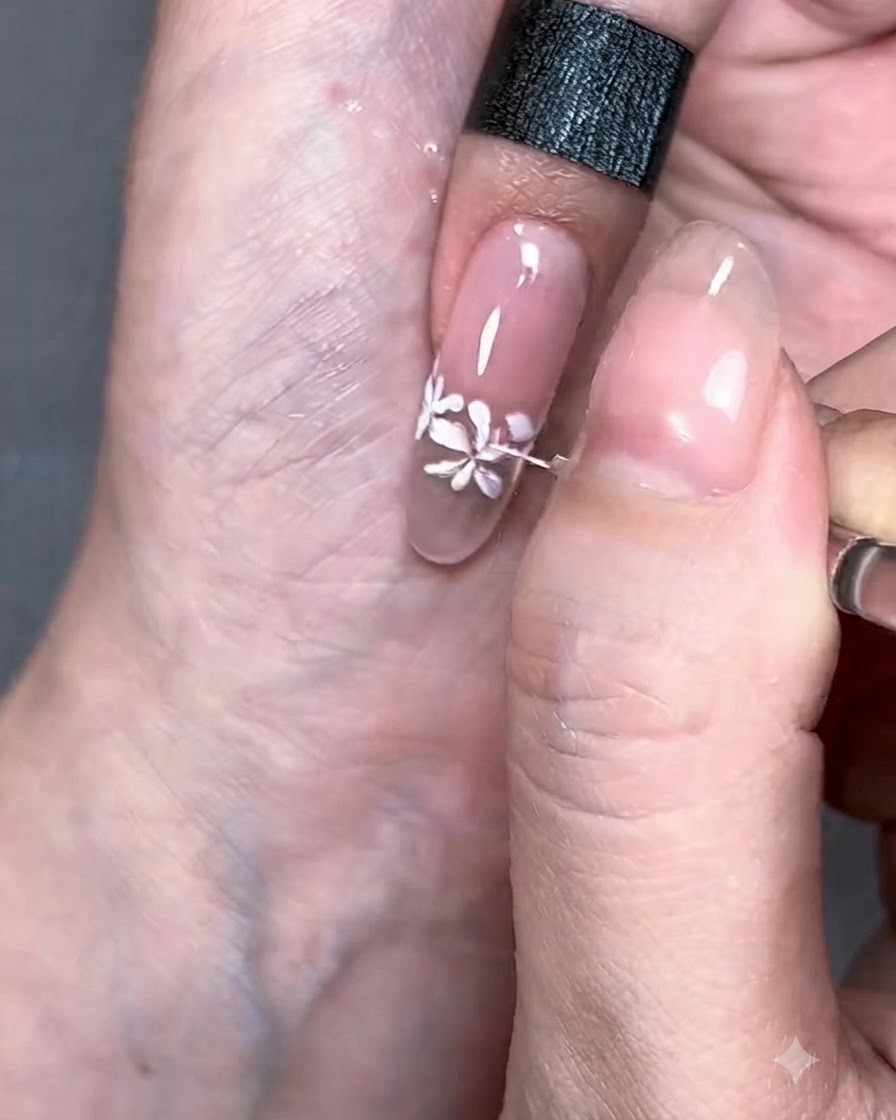 Un pennello liner sottile che disegna delicate linee bianche che si estendono dai fiori dipinti.