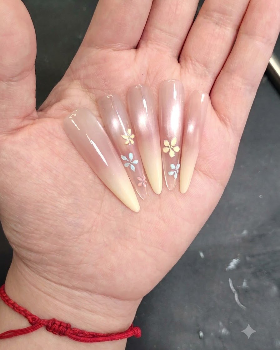Uno scatto dettagliato di un pennello per nail art che applica un piccolo dettaglio di petalo su ununghia dipinta.