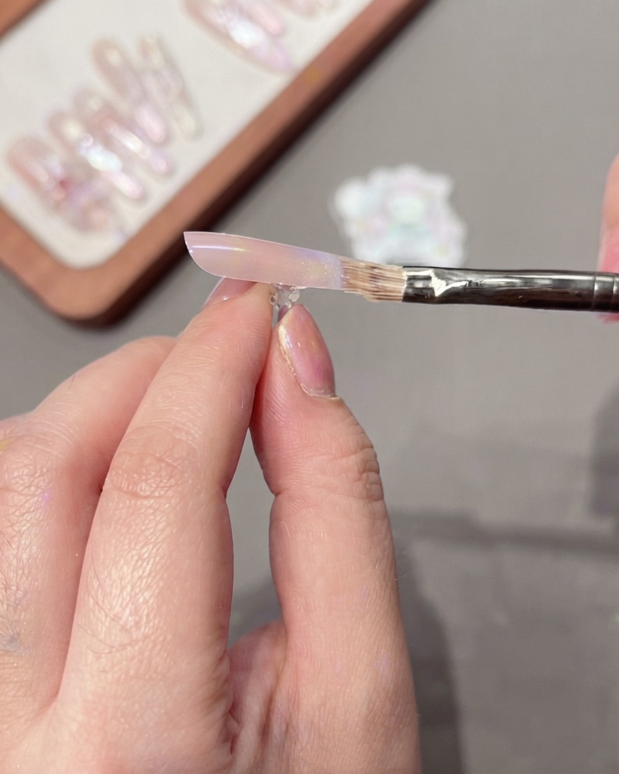 Un pennello che sfiora delicatamente la superficie dellunghia per creare una sfumatura di colore liscia.