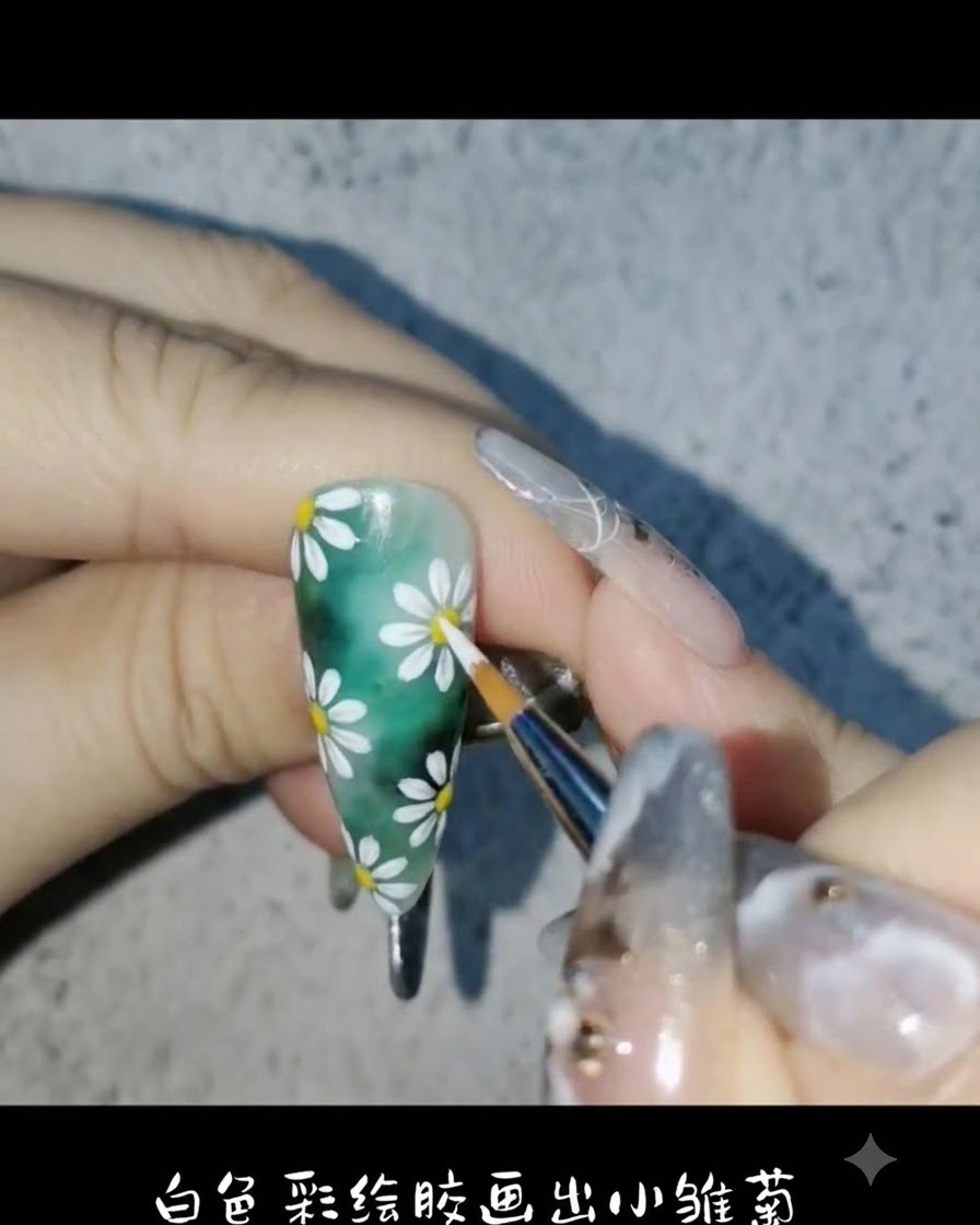 Un pennello liner che utilizza gel da pittura bianco per disegnare delicati petali di margherita sullo sfondo verde dellunghia.