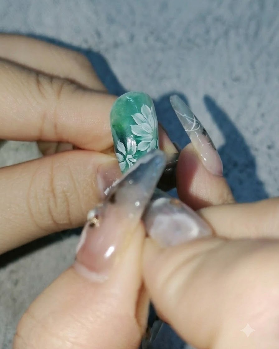 Una vista ravvicinata di unonicotecnica che aggiunge petali bianchi più profondi alle margherite su un design per unghie verde.