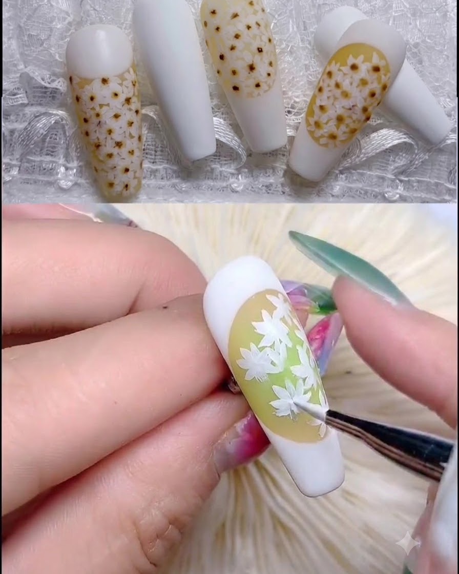 Un pennello sottile applica punti traslucidi rosa chiaro al centro dei petali di margherita.
