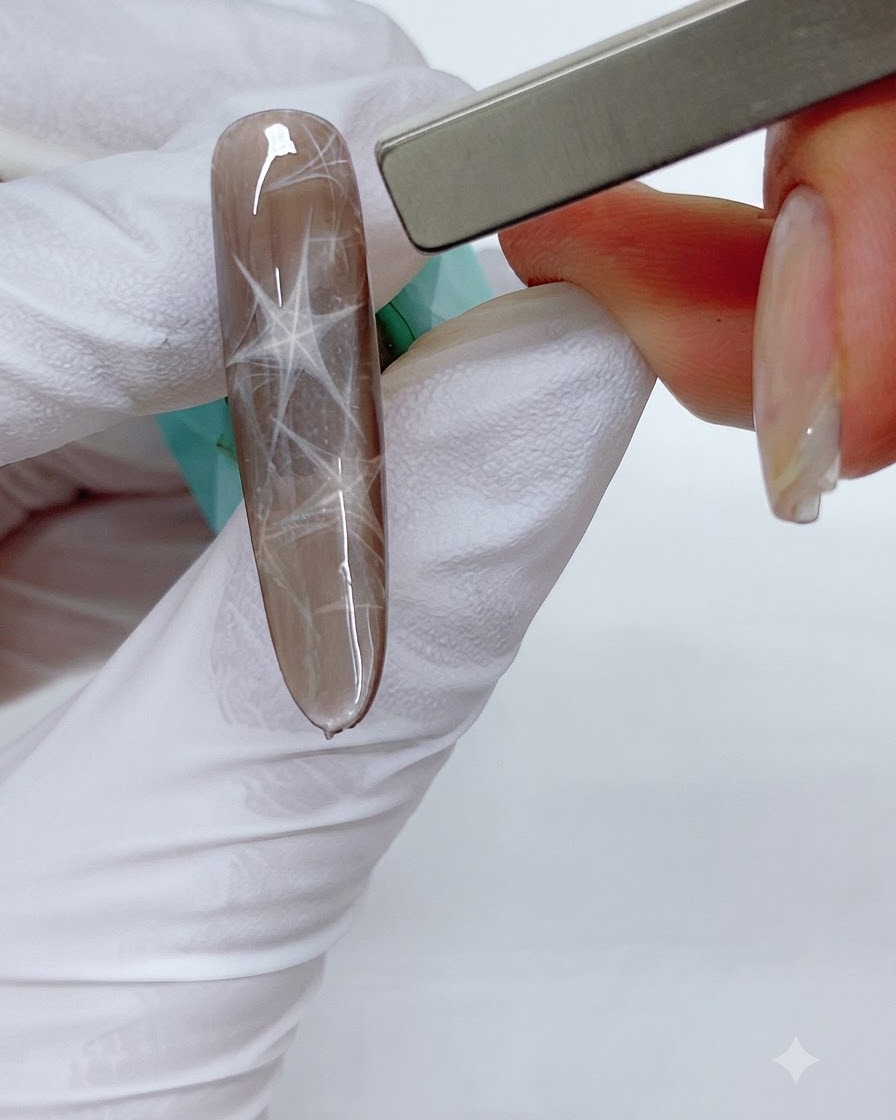 Un magnete a barra rettangolare sopra ununghia marrone per spingere i riflessi magnetici in un motivo triangolare.