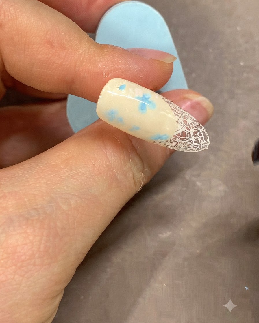 Un pennello fine che applica una linea in gel bianco lungo il bordo della french manicure.