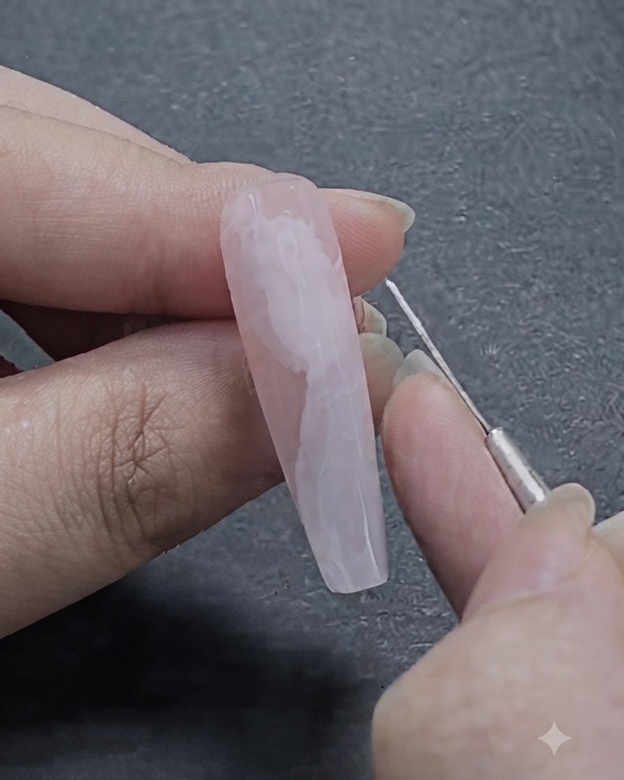 Un pennello liner fine per nail art disegna delicate linee bianche sul design a nastro in blooming gel semi-sfumato.