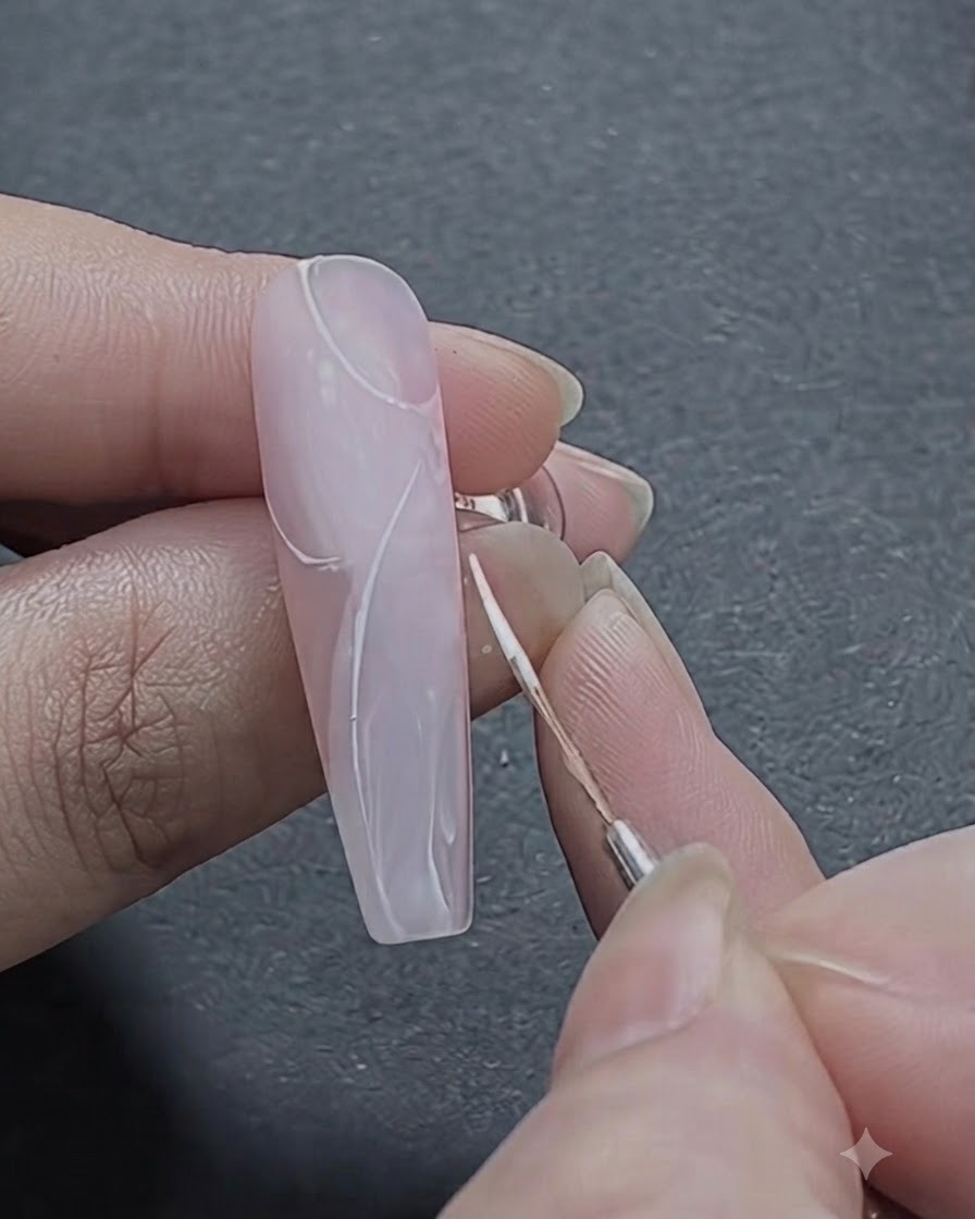 Un pennello fine che delinea i primi tratti bianchi curvi di un modello di rosa sulla sezione superiore dellunghia.
