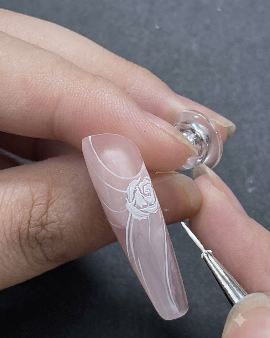 Uno scatto in primo piano che mostra sottili accenti di petali bianchi aggiunti attorno al design principale della rosa con un pennello liner.