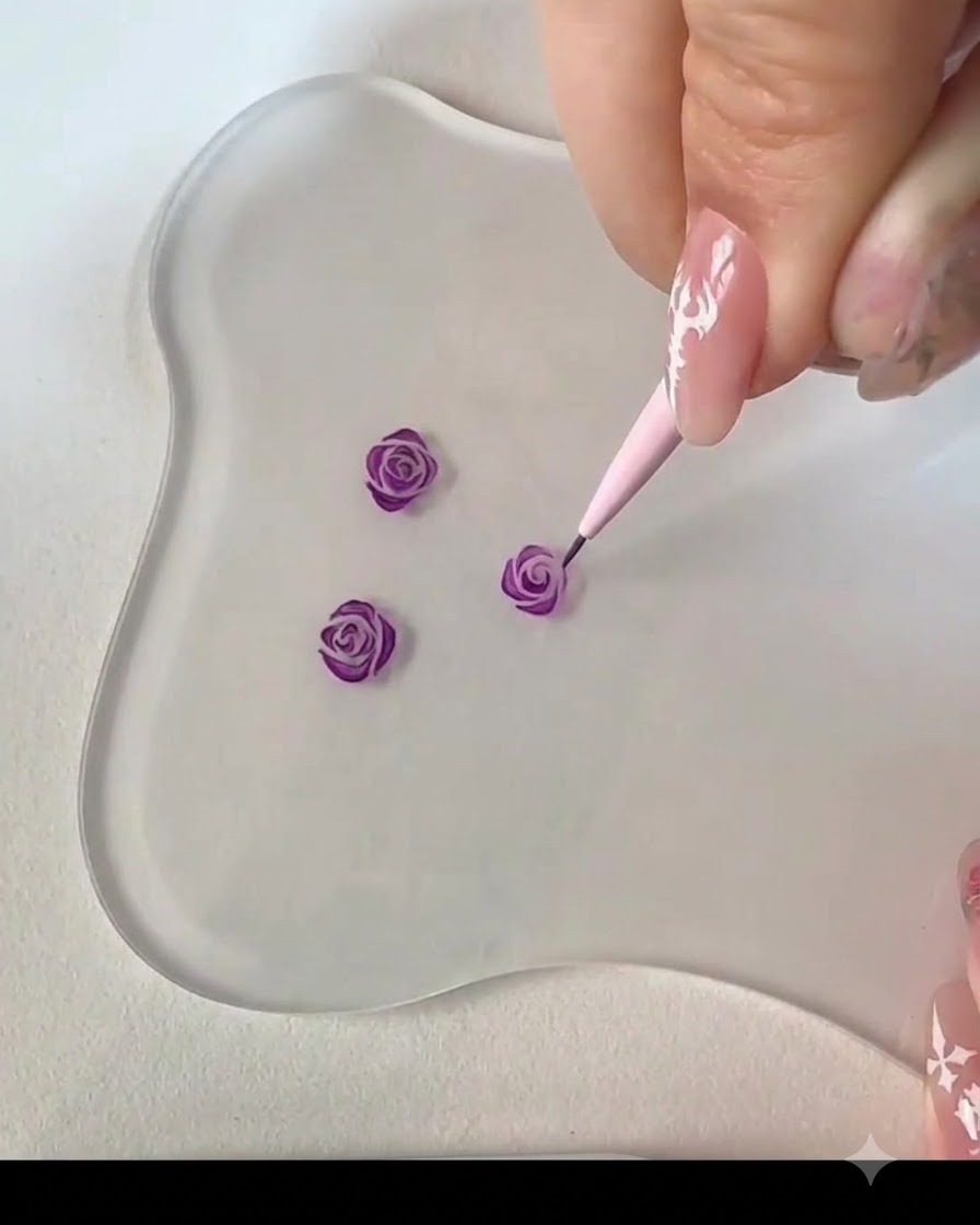 Un pennello liner fine che aggiunge un tratto ricurvo adiacente per completare il centro del bocciolo di rosa viola.