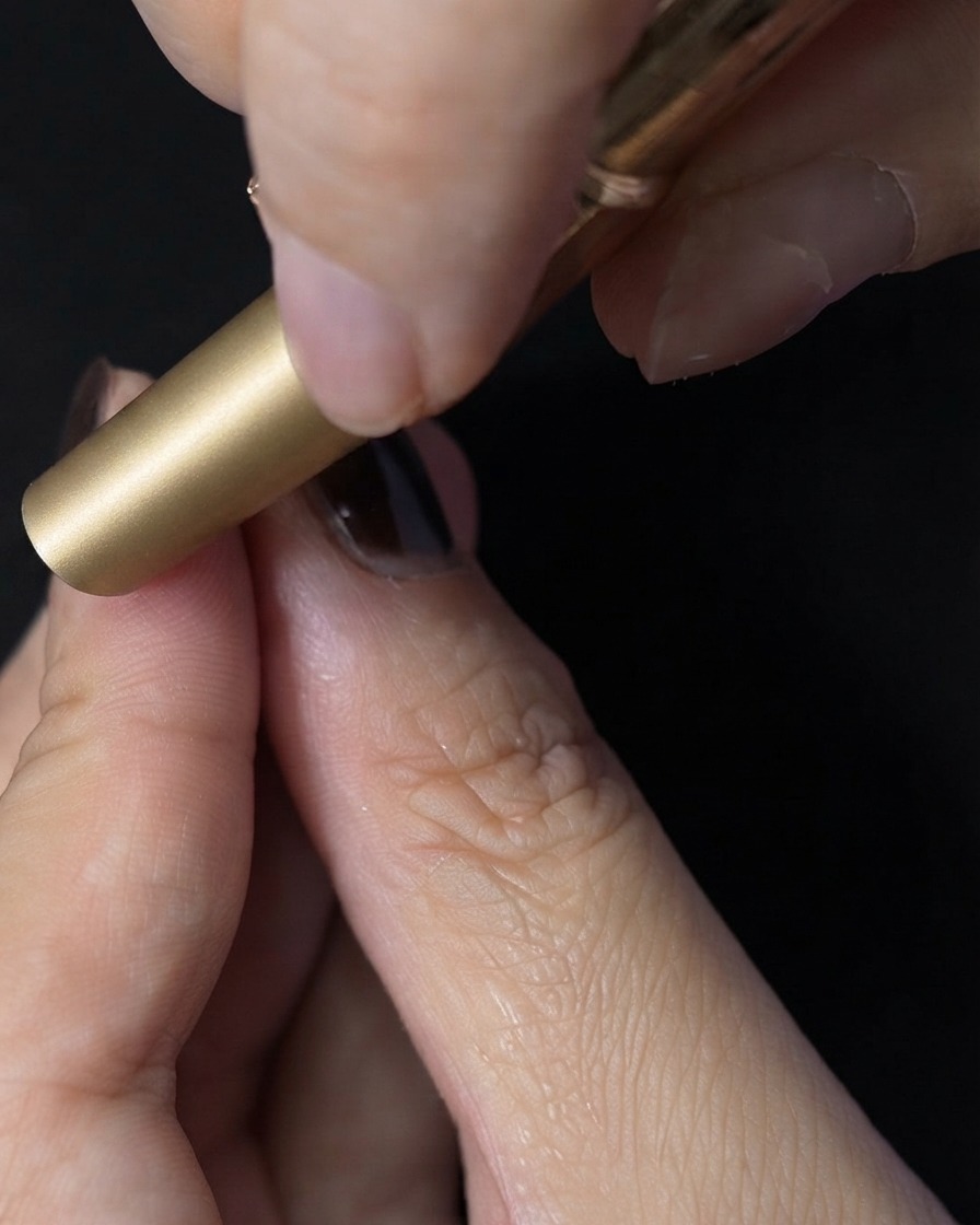 Ununghia inserita allinterno di una mini lampada UV LED per la polimerizzazione del top coat.