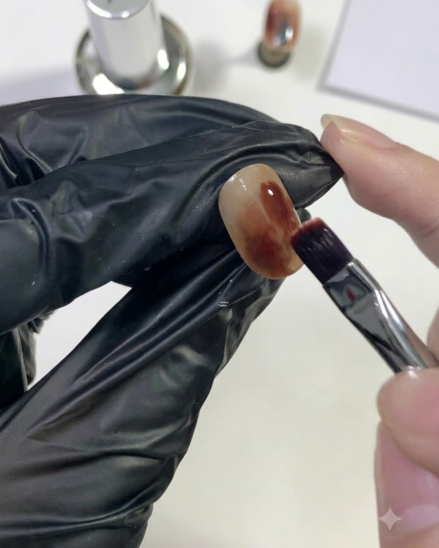 Un pennello che applica del gel rosso scuro su unarea localizzata dellunghia.
