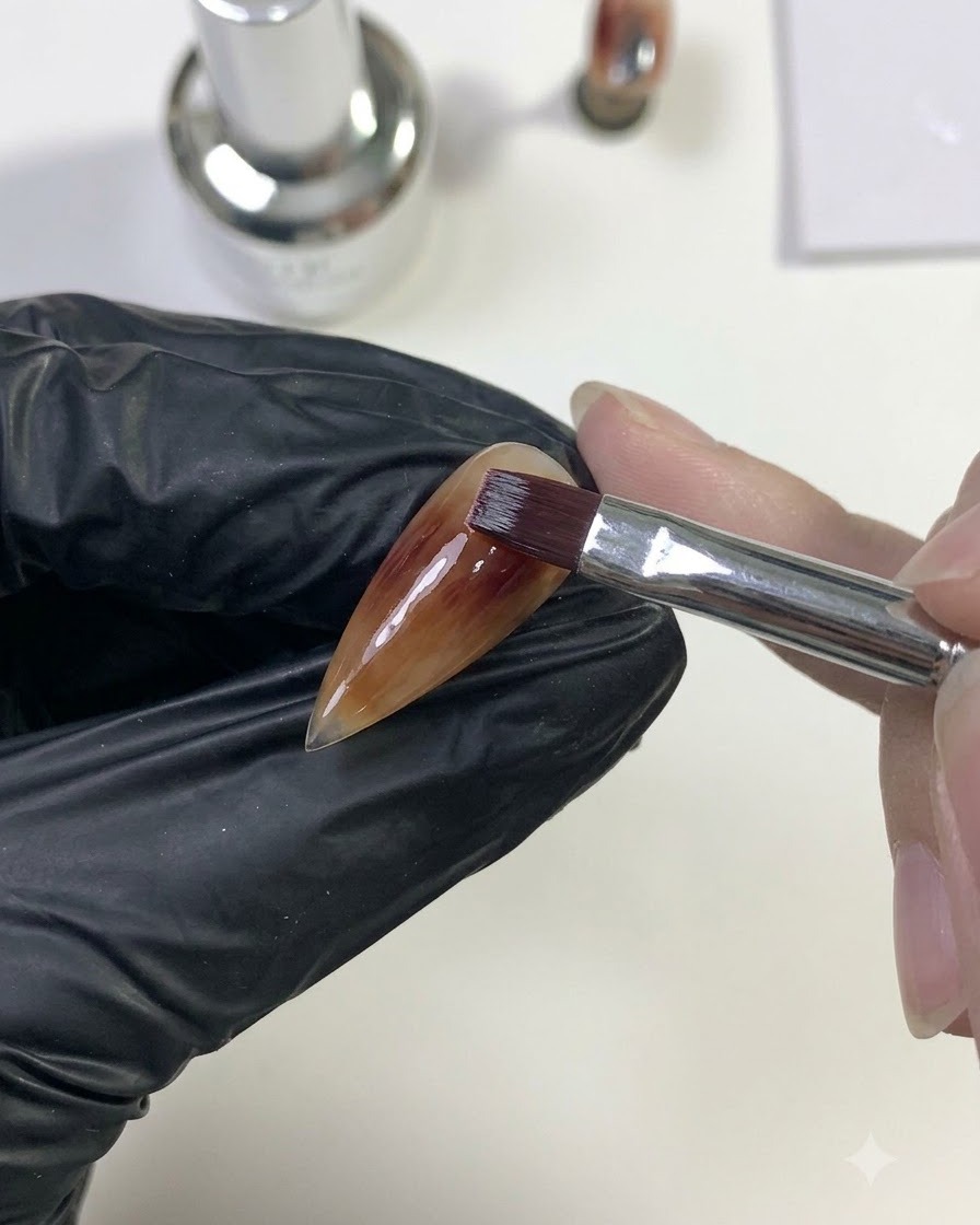 Un pennello che sfuma il gel rosso scuro verso lesterno per fonderlo con lo strato di base caramello.