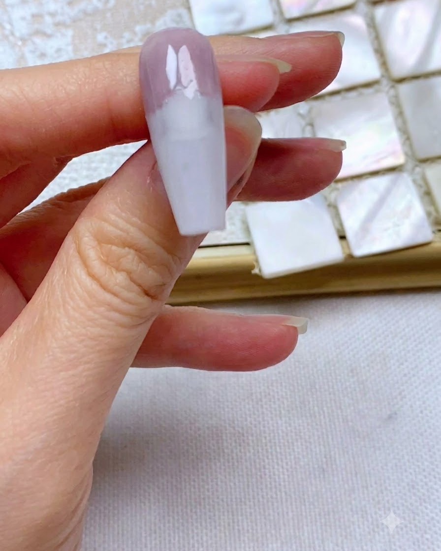 Ununghia che mostra un bordo dritto e pulito di gel grigio-viola applicato sul terzo superiore.