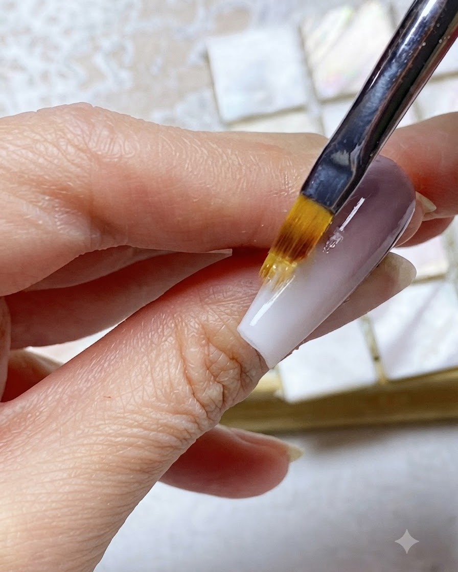 Un pennello ombré sfuma il gel della punta bianca verso lalto nella sezione superiore viola dellunghia.
