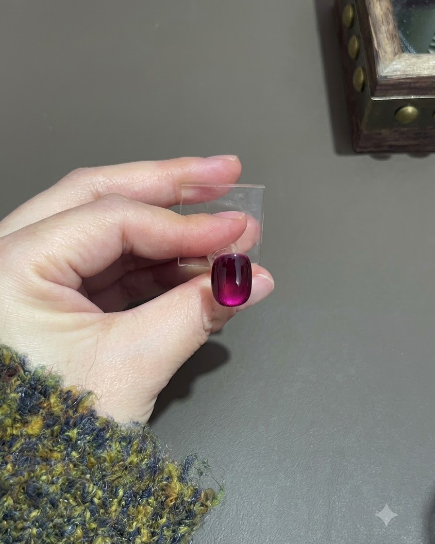 Ununghia cat-eye viola polimerizzata che mostra un profondo effetto sfumato su un supporto da esposizione.