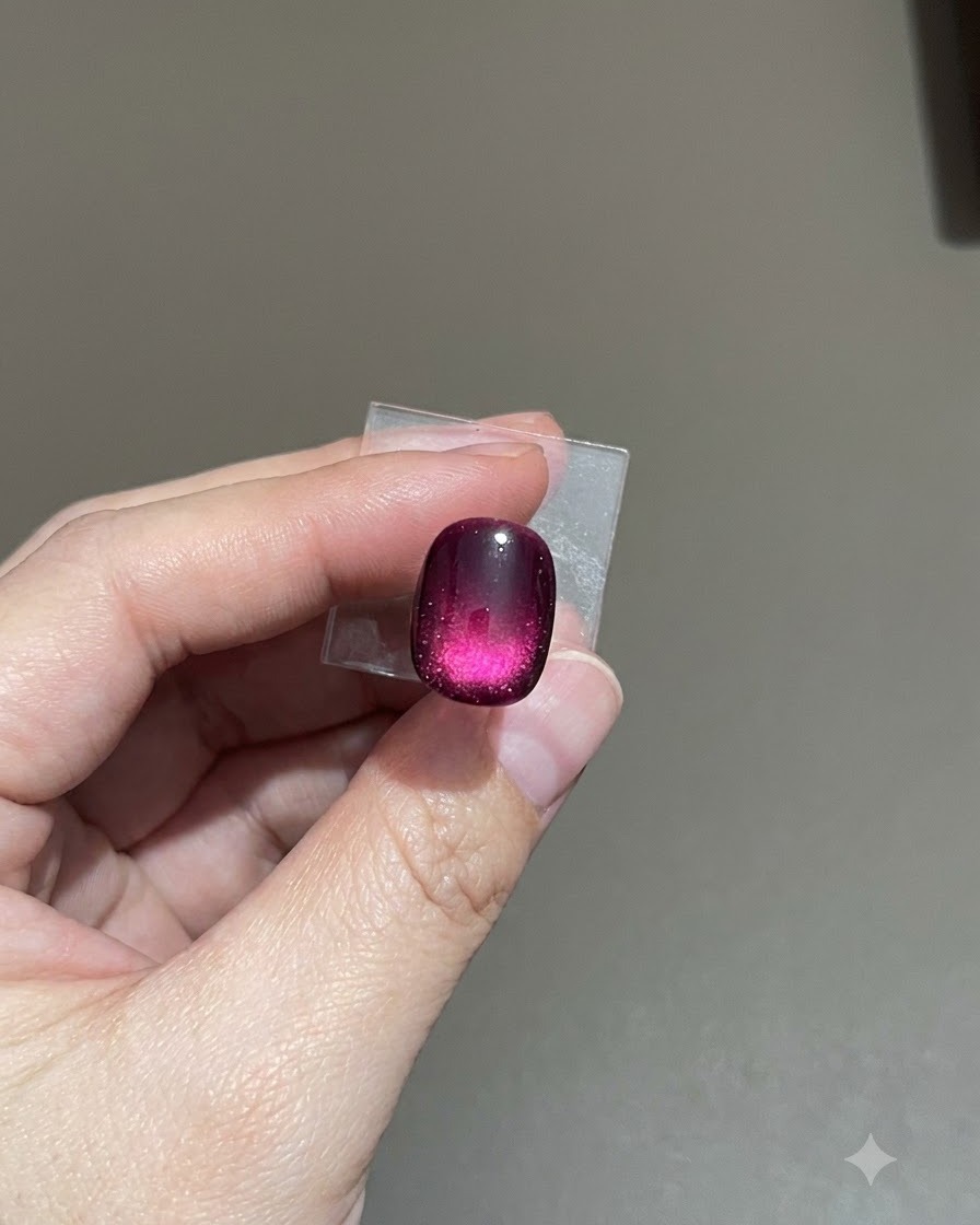 Una vista ravvicinata di ununghia cat-eye frosted viola mentre il top coat opaco si livella.