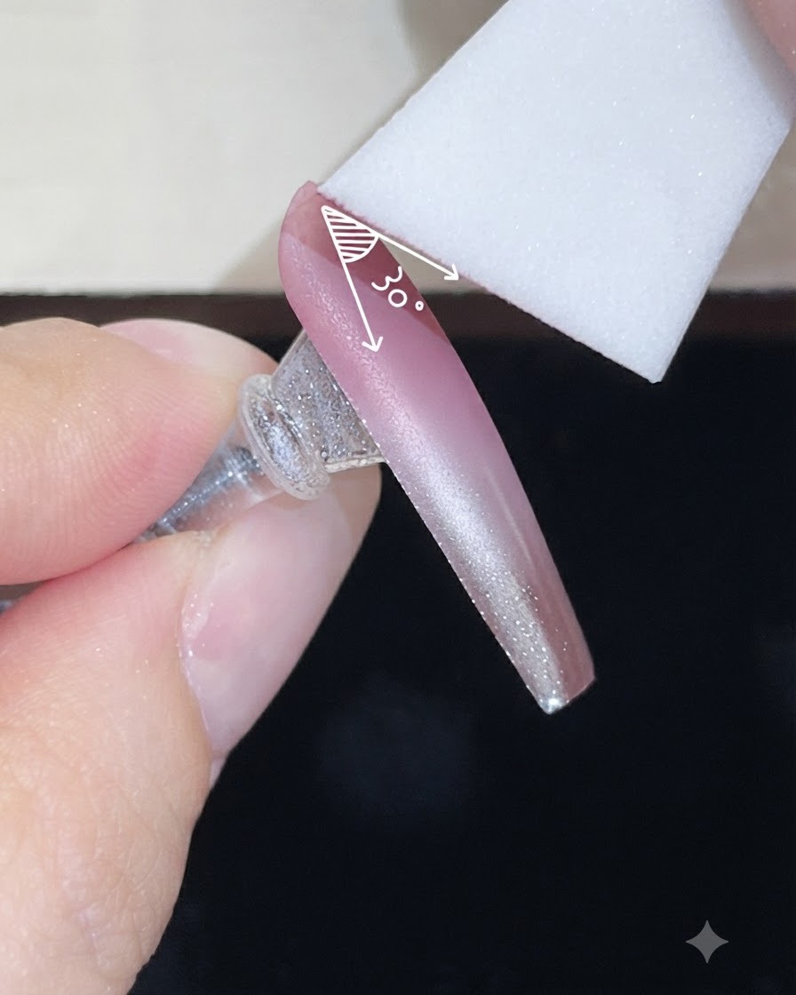 Una spugnetta che applica un secondo strato di gel colorato su ununghia nude sfumata.