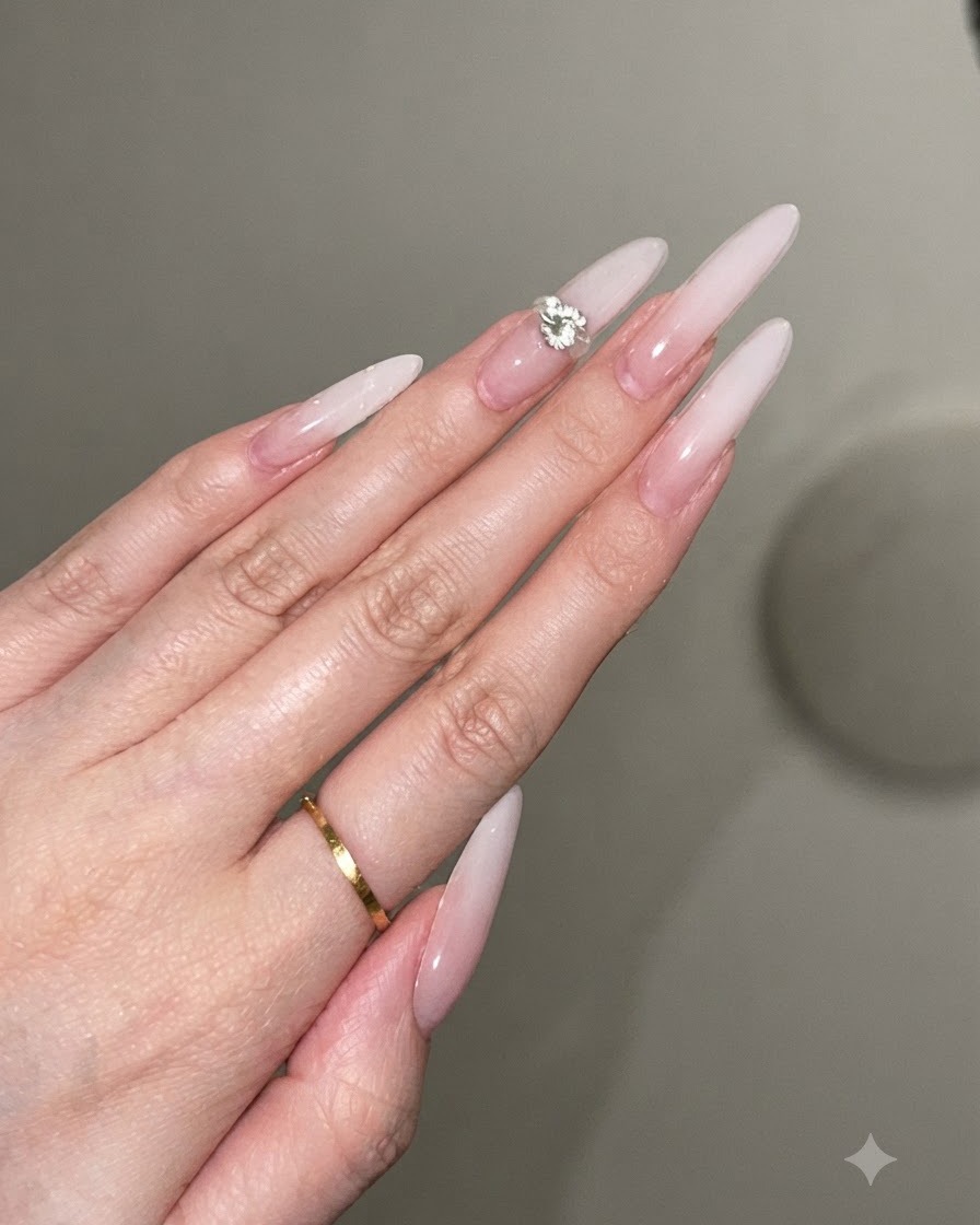 Una goccia di adesivo in gel trasparente posizionata al centro di ununghia a stiletto decorata.