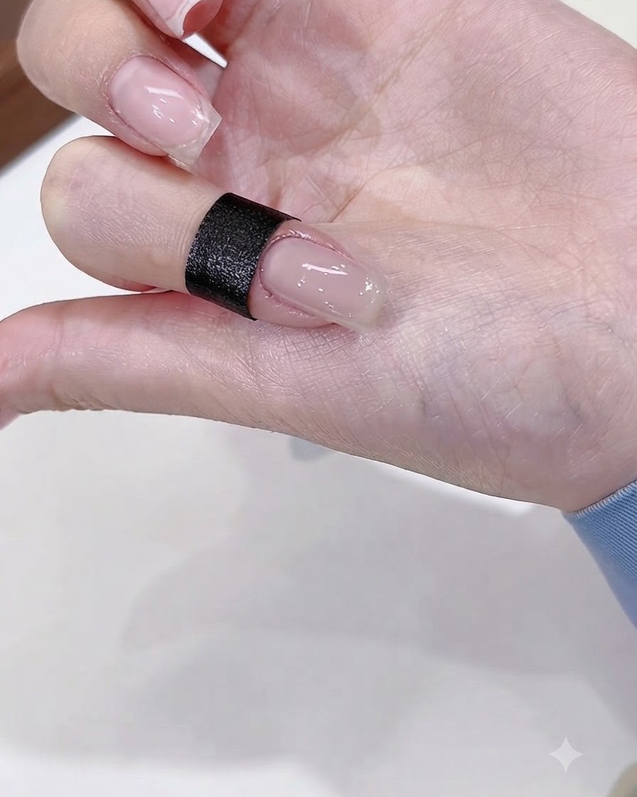 Un primo piano di ununghia dipinta con uno strato di base gel nude lucido.