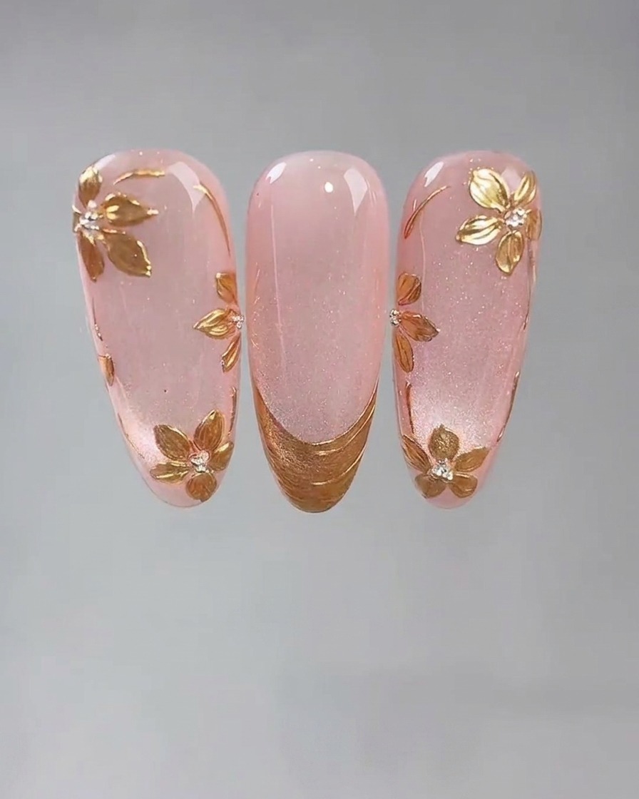 Uno scatto ravvicinato di uno strumento fine che posiziona un piccolo punto di colla adesiva per unghie su ununghia in gel cat-eye rosa.