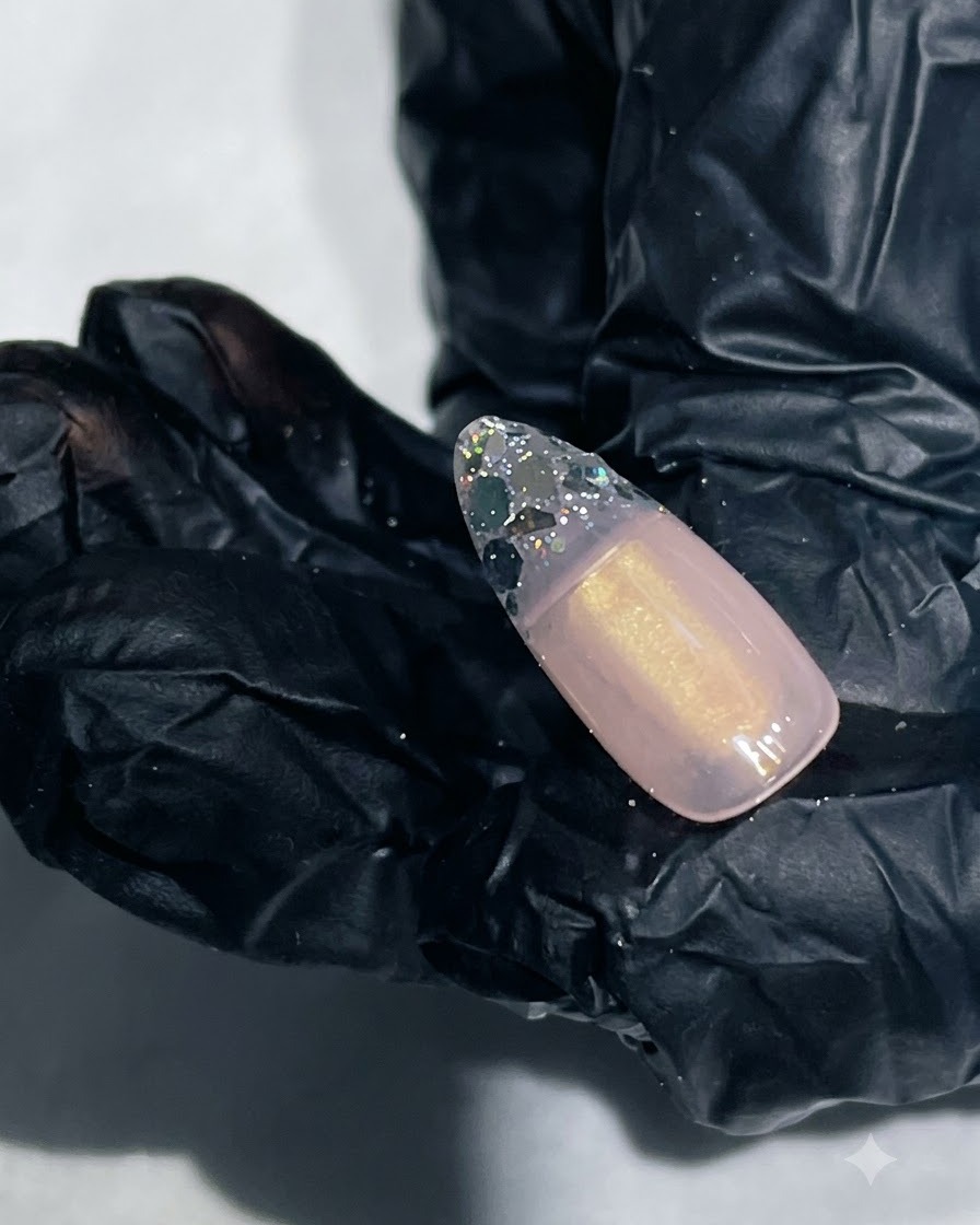 Un primo piano di ununghia con gel rinforzante liscio che incapsula la punta con glitter.