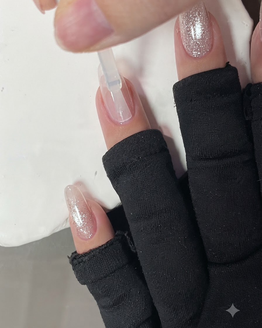 Una base coat trasparente applicata su ununghia con un pennello.