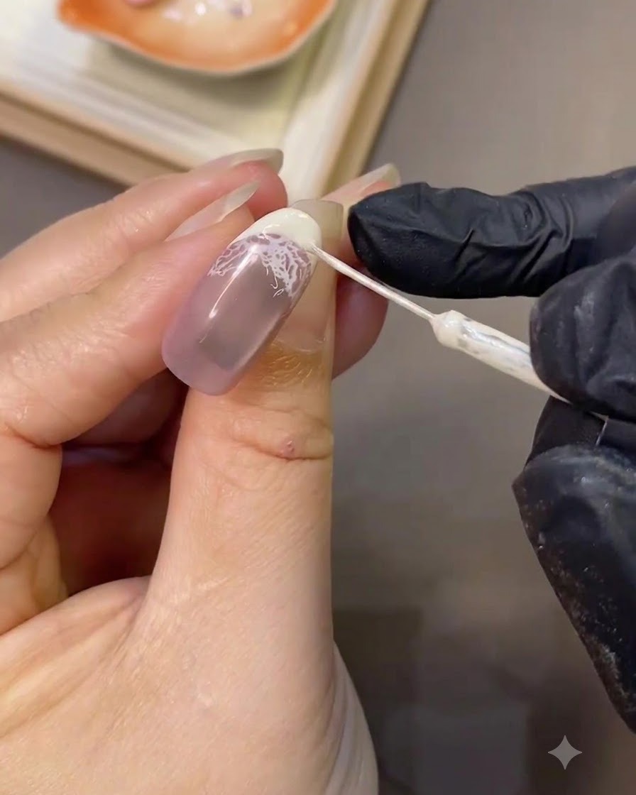 Un pennello liner sottile che rifinisce con precisione la nitida curva bianca di una punta French su ununghia curata.
