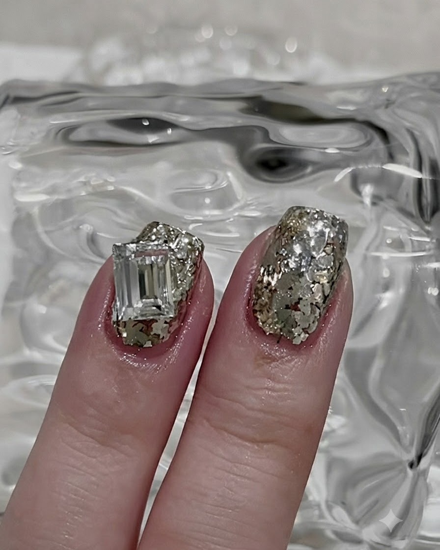 Un pennello sottile per nail art che preleva una piccola porzione di polvere glitter argento sfusa.