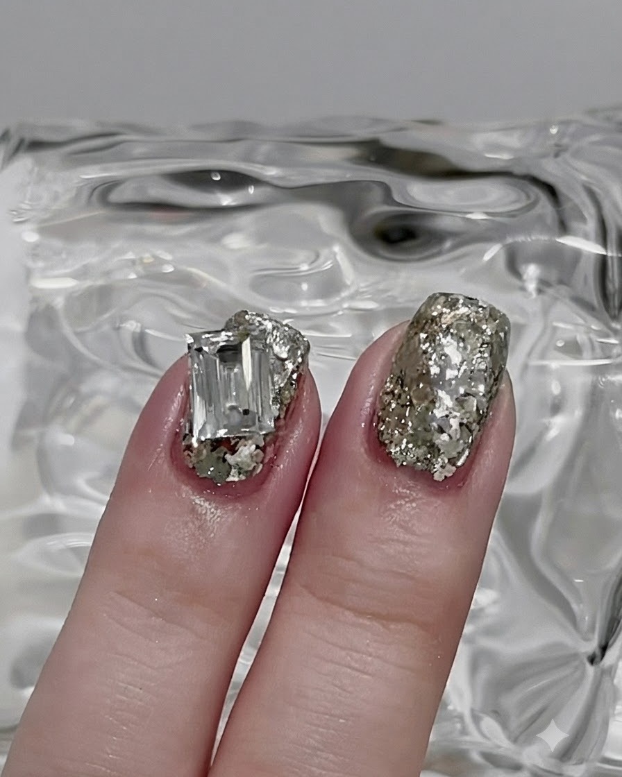 Un pennello per unghie che livella i glitter argento in uno strato sottile e uniforme su tutta lunghia.