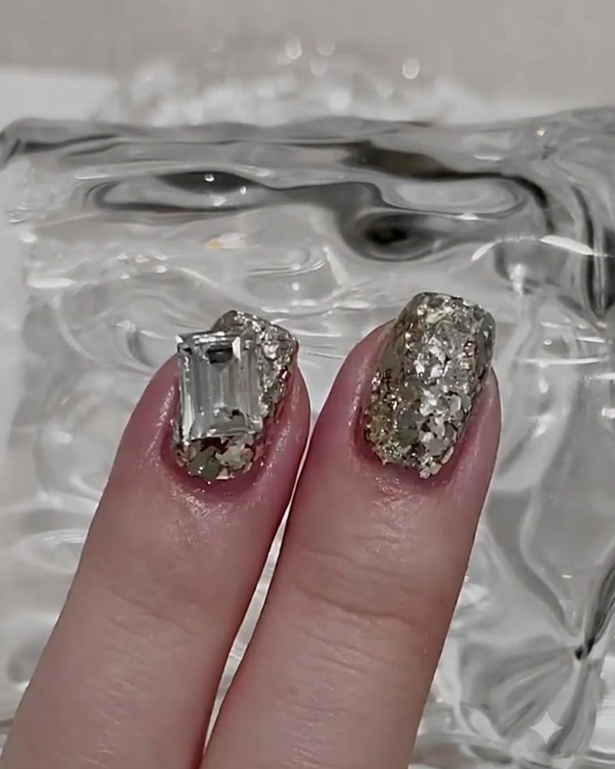 Un pennello che applica un top coat lucido sopra uno strato di unghia con glitter.