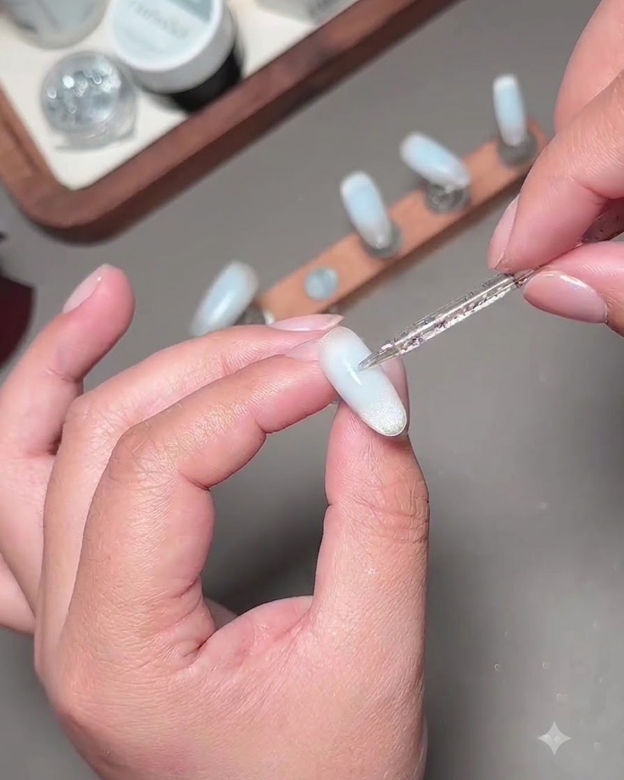 Un pennello fine per nail art che applica un secondo strato di gel blu per scurire il centro dellunghia.