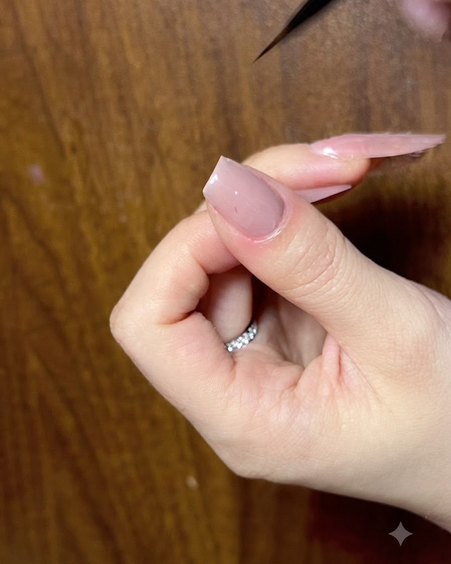 Un primo piano di ununghia che viene rifinita con un pennello liner sottile per garantire contorni del fiocco puliti.