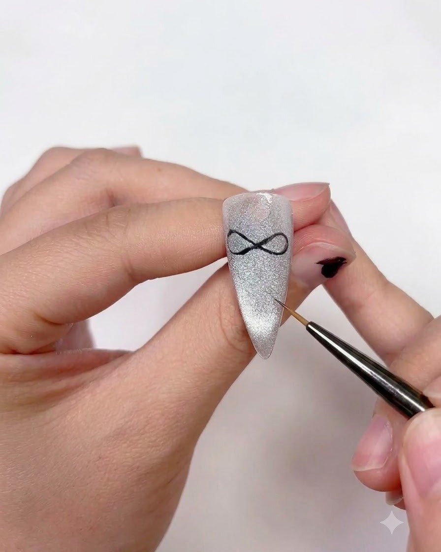 Unonicotecnica che usa un pennello liner fine per aggiungere due code di nastro curve che si estendono verso il basso dal centro della nail art del fiocco.