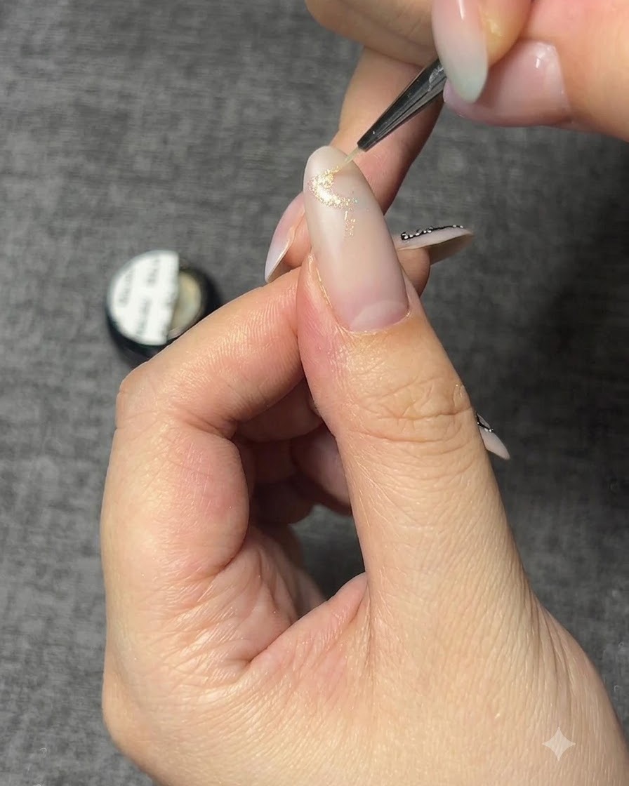 Primo piano di ununghia con il contorno di una farfalla in gel glitterato.