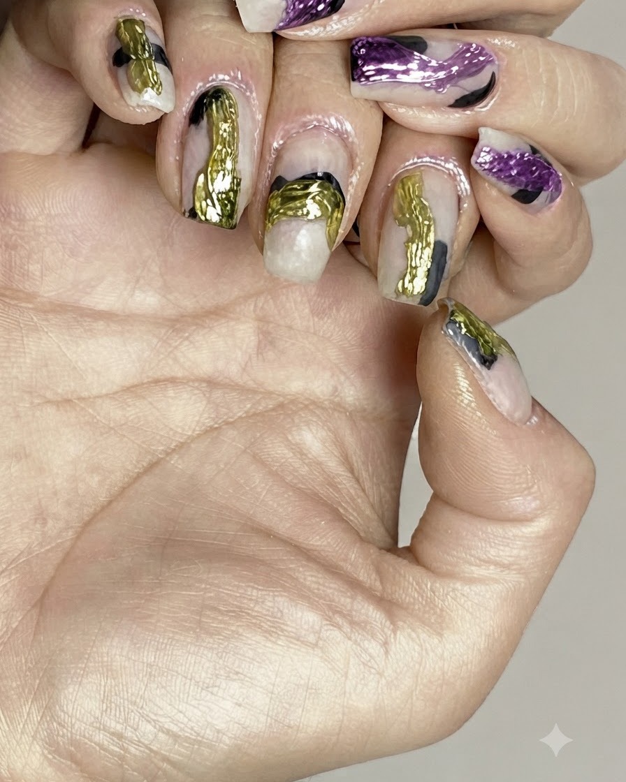 Un pennello applica un top coat lucido trasparente sopra la nail art astratta finita.